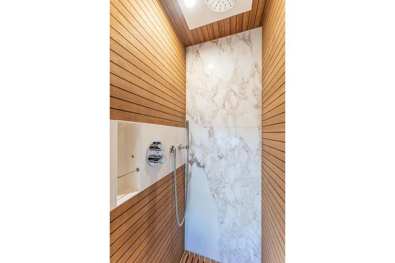  Yacht Photos Pics Luxurious shower in 2022 Azimut GRANDE 25 METRI yacht with wood paneling and marble accents.