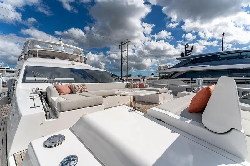  Yacht Photos Pics Luxurious 2022 Azimut GRANDE 25 METRI yacht with elegant outdoor seating under a vibrant sky.