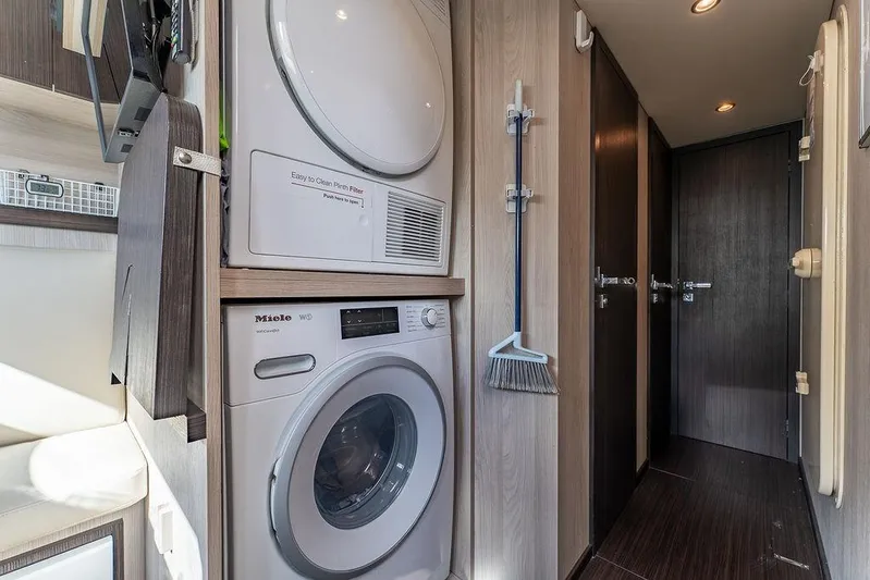  Yacht Photos Pics Laundry area inside 2022 Azimut GRANDE 25 METRI yacht, featuring Miele washer and dryer.