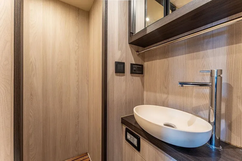  Yacht Photos Pics Luxurious bathroom interior of 2022 Azimut GRANDE 25 METRI yacht with modern sink and wood accents.