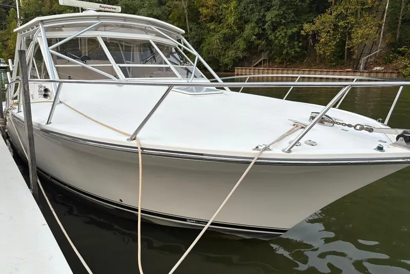  Yacht Photos Pics 2006 Carolina Classic 32 boat docked on calm water, surrounded by lush greenery.