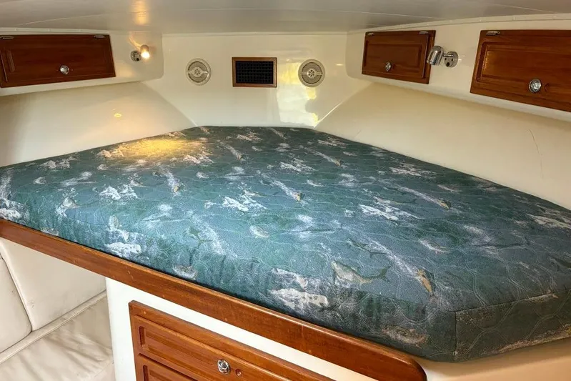  Yacht Photos Pics 2006 Carolina Classic 32 cabin interior with a patterned mattress and wooden storage cabinets.