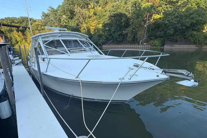  Yacht Photos Pics 2006 Carolina Classic 32 boat docked on calm water, surrounded by lush greenery.