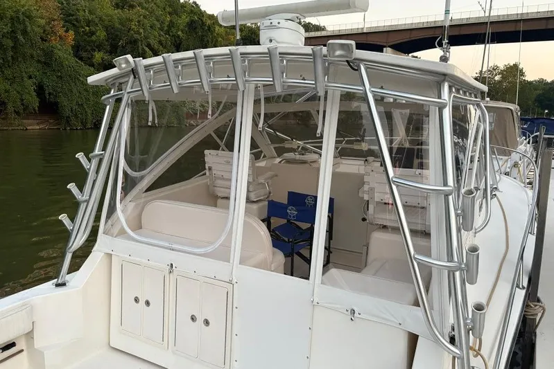  Yacht Photos Pics 2006 Carolina Classic 32 boat with enclosed cockpit, docked by a river.
