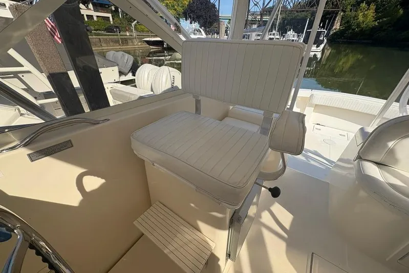  Yacht Photos Pics Captain's chair on a 2006 Carolina Classic 32 boat, docked near a scenic waterfront.