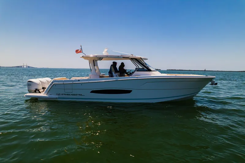 My Honey Yacht Photos Pics 2023 Regal 38 SAV boat cruising on open water under clear blue sky.