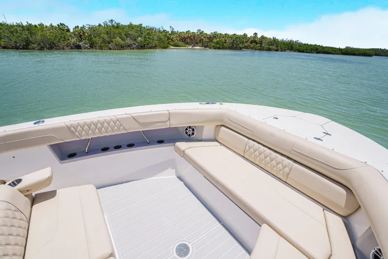 My Honey Yacht Photos Pics 2023 Regal 38 SAV boat interior with beige seating, on a calm lake.