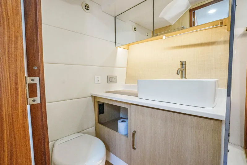 My Honey Yacht Photos Pics 2023 Regal 38 SAV bathroom with modern sink, wooden cabinetry, and mirror.