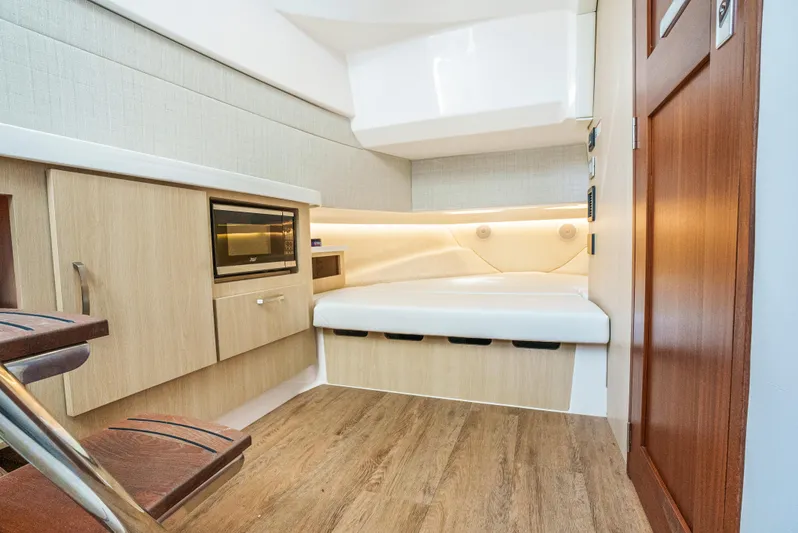 My Honey Yacht Photos Pics 2023 Regal 38 SAV cabin interior with modern wood finish and cozy bed.