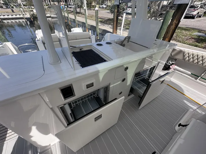 My Honey Yacht Photos Pics 2023 Regal 38 SAV boat kitchen area with grill, sink, and storage compartments.