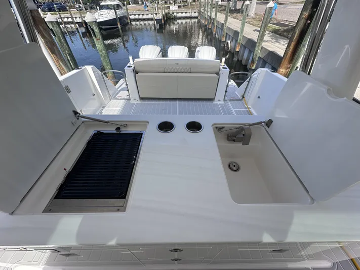 My Honey Yacht Photos Pics 2023 Regal 38 SAV boat deck with grill and sink, docked at marina.