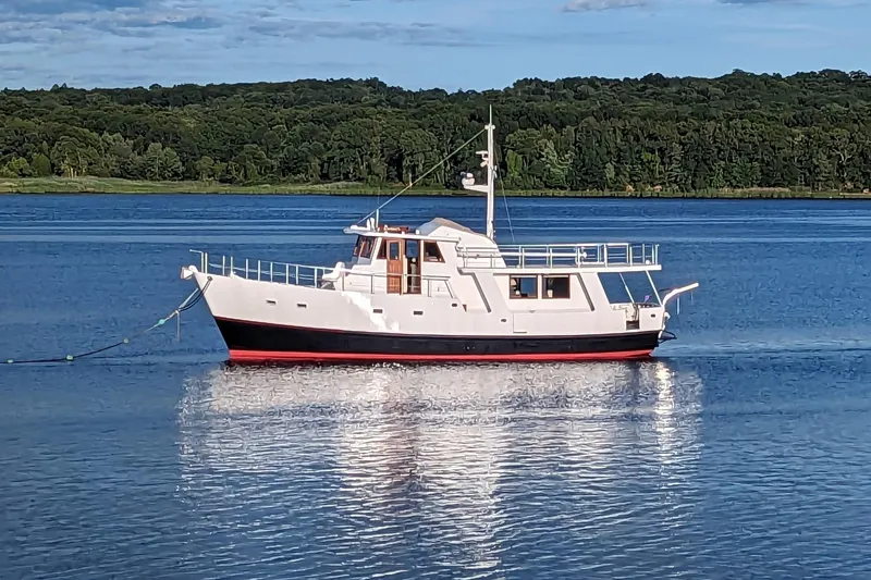  Yacht Photos Pics Custom Jack Gilbert 50 Trawler, 1999, anchored on a serene lake with forested background.