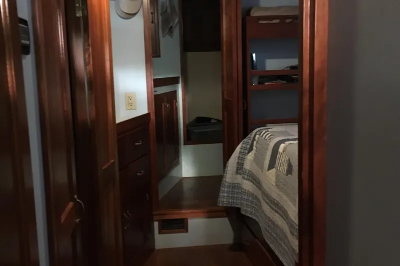  Yacht Photos Pics Interior of 1999 Custom Jack Gilbert 50 Trawler with wooden cabinetry and cozy bedding.