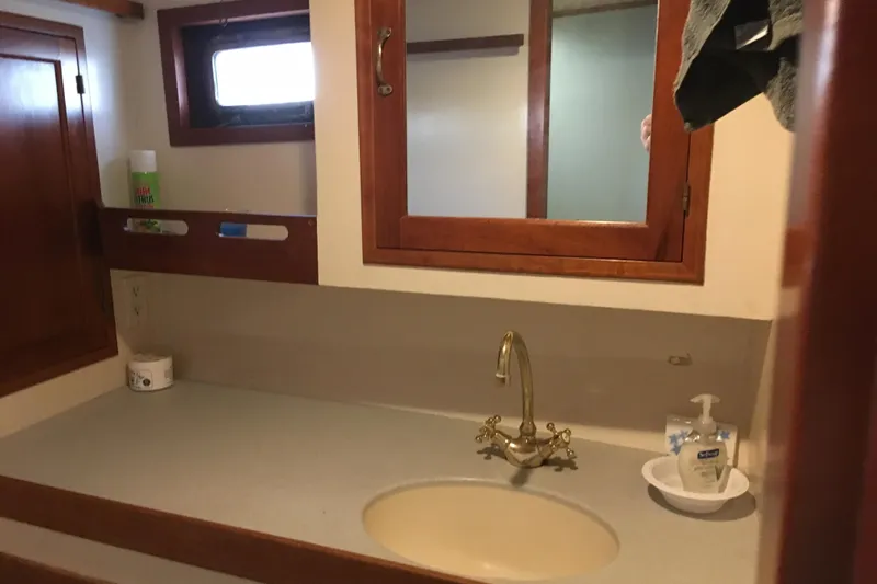  Yacht Photos Pics Bathroom sink area on a 1999 Custom Jack Gilbert 50 Trawler with wooden cabinetry.