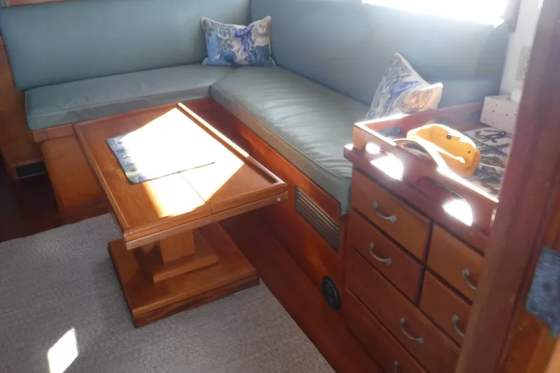  Yacht Photos Pics Cozy interior of 1999 Custom Jack Gilbert 50 Trawler with wooden furniture and cushioned seating.