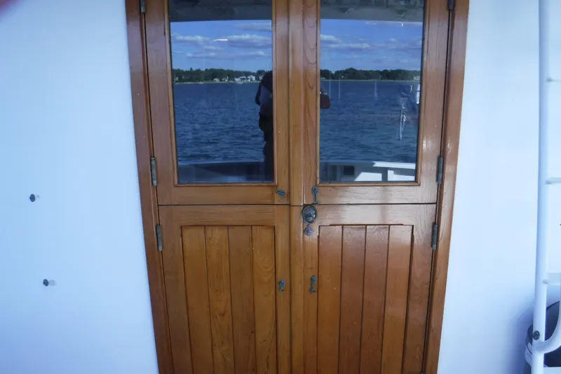  Yacht Photos Pics Wooden door on 1999 Custom Jack Gilbert 50 Trawler, overlooking serene water view.