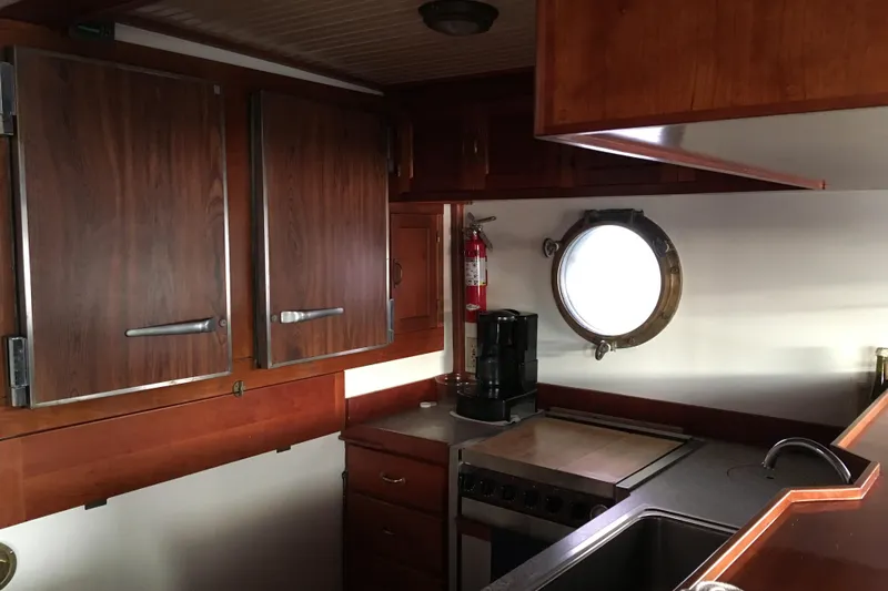  Yacht Photos Pics Galley kitchen in 1999 John Gilbert 50 Trawler with wooden cabinets and porthole window.