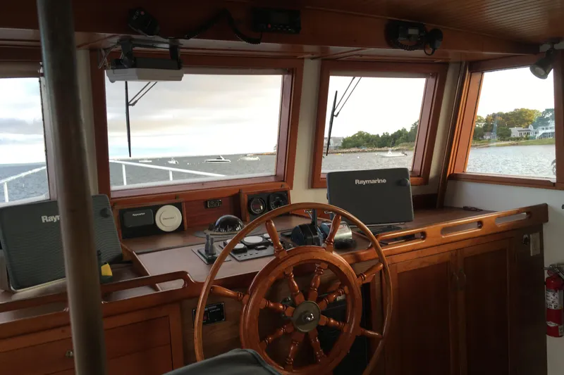  Yacht Photos Pics Interior view of 1999 Custom John Gilbert 50 Trawler helm with wooden steering wheel and navigation equipment.