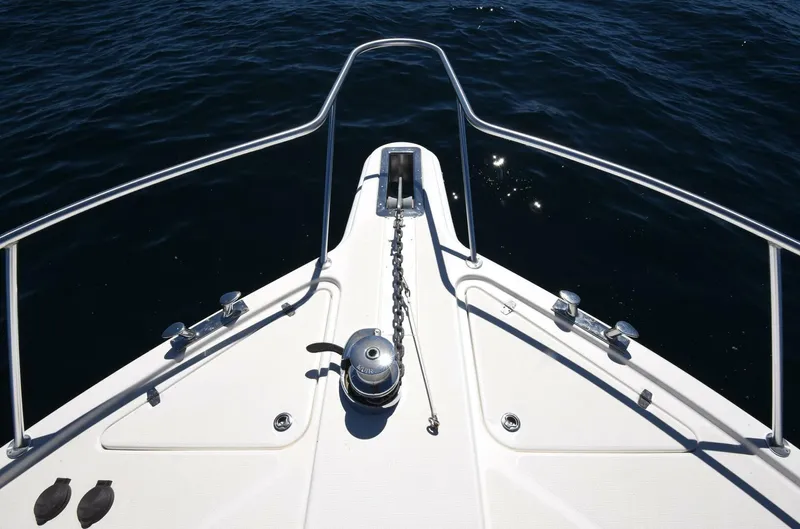 Viviendo El Sueño Yacht Photos Pics Bow of 2005 Riviera 51 yacht with anchor chain over deep blue water.