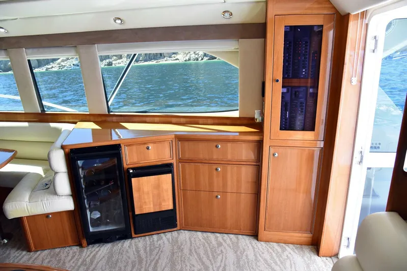 Viviendo El Sueño Yacht Photos Pics Interior of a 2005 Riviera 51 yacht with wooden cabinetry and a mini fridge.