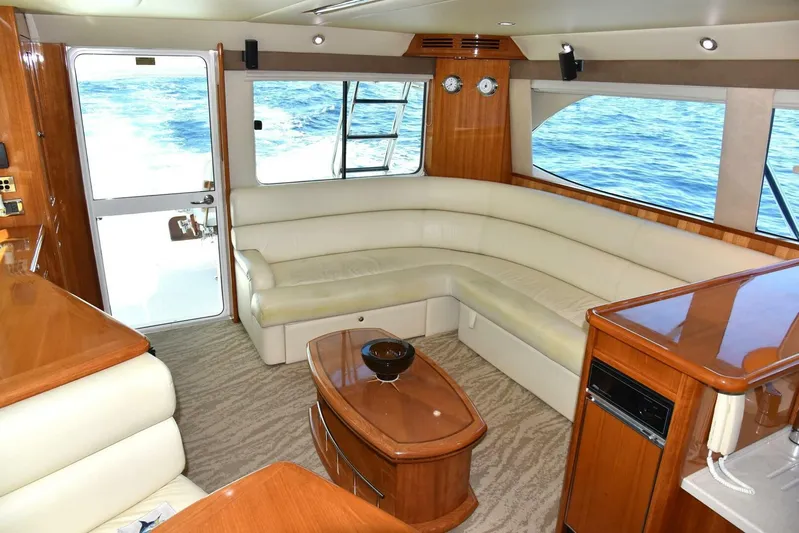 Viviendo El Sueño Yacht Photos Pics Luxurious interior of a 2005 Riviera 51 yacht with cream leather seating and wooden accents.