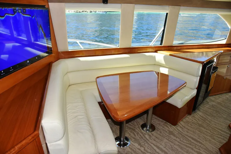 Viviendo El Sueño Yacht Photos Pics Luxurious interior of 2005 Riviera 51 yacht with leather seating and wooden table.
