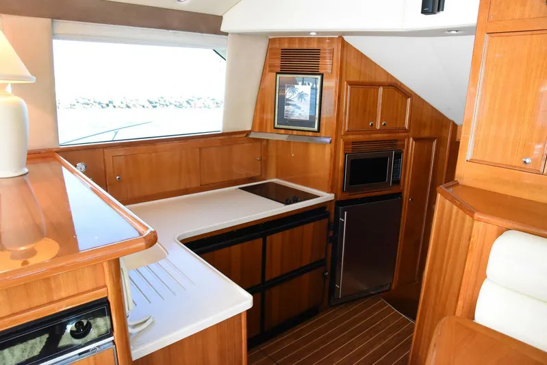 Viviendo El Sueño Yacht Photos Pics Interior of 2005 Riviera 51 yacht kitchen with wood cabinetry and modern appliances.