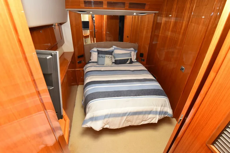 Viviendo El Sueño Yacht Photos Pics Luxurious bedroom interior of a 2005 Riviera 51 yacht with striped bedding.