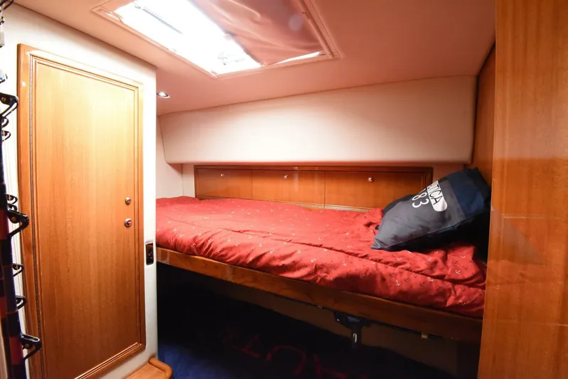 Viviendo El Sueño Yacht Photos Pics 2005 Riviera 51 yacht cabin with red bedding and wooden interior.