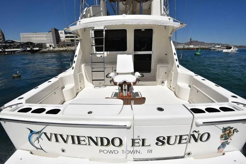 Viviendo El Sueño Yacht Photos Pics 2005 Riviera 51 yacht with "Viviendo El Sueño" on the stern, docked in a marina.
