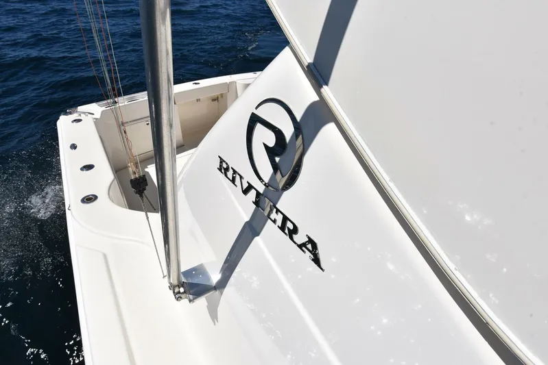 Viviendo El Sueño Yacht Photos Pics 2005 Riviera 51 yacht stern on water, showcasing logo and sleek design.