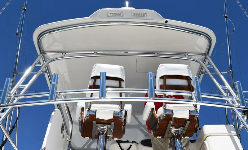 Viviendo El Sueño Yacht Photos Pics Flybridge of 2005 Riviera 51 yacht with two helm chairs against clear blue sky.