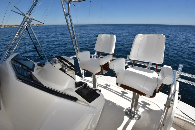 Viviendo El Sueño Yacht Photos Pics 2005 Riviera 51 yacht helm with dual white captain chairs overlooking the ocean.