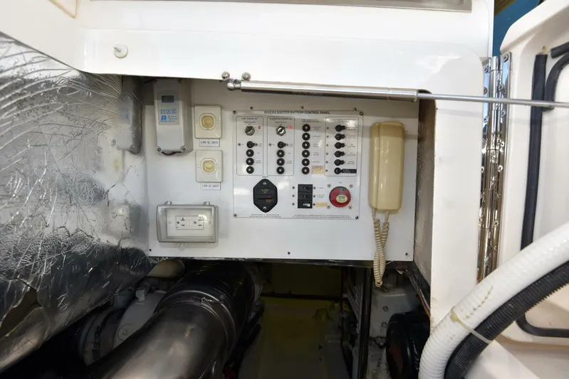 Viviendo El Sueño Yacht Photos Pics Control panel in a 2005 Riviera 51 yacht engine room, featuring switches and a phone.