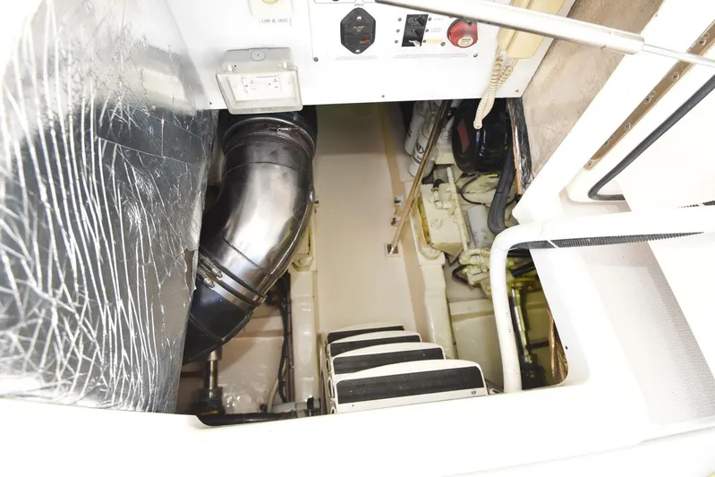 Viviendo El Sueño Yacht Photos Pics Engine room of a 2005 Riviera 51 yacht, featuring mechanical components and access steps.