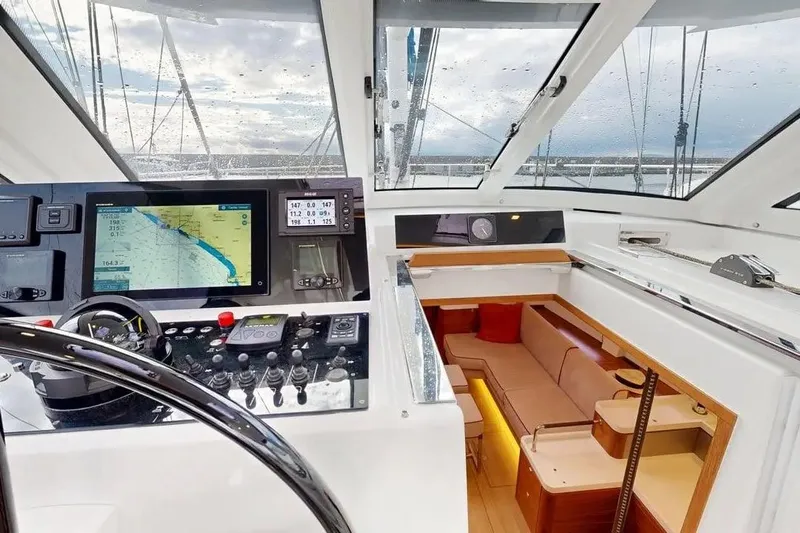 Amel 50 Yacht Photos Pics 2023 Amel 50 yacht interior with navigation controls and cozy seating area.