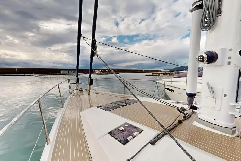 Amel 50 Yacht Photos Pics Deck view of 2023 Amel 50 sailboat in a marina under cloudy skies.