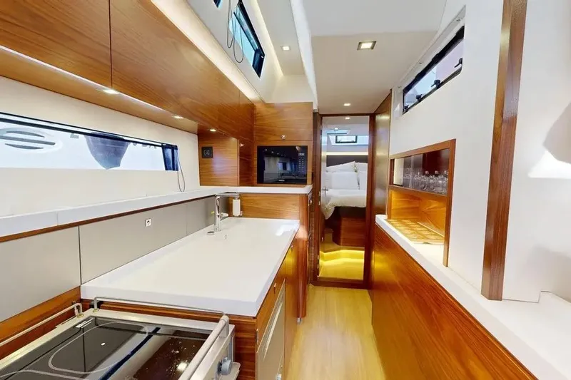 Amel 50 Yacht Photos Pics Luxurious interior of 2023 Amel 50 yacht featuring modern kitchen and cozy bedroom.