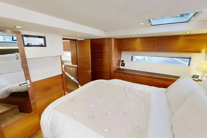 Amel 50 Yacht Photos Pics Luxurious interior of 2023 Amel 50 yacht with elegant wood finish and cozy bedding.