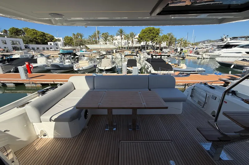  Yacht Photos Pics Luxurious 2024 Prestige 590 yacht with elegant seating, docked at a scenic marina.