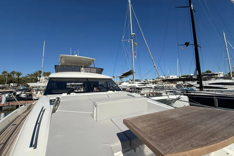  Yacht Photos Pics 2024 Prestige 590 yacht docked in marina under clear blue sky.