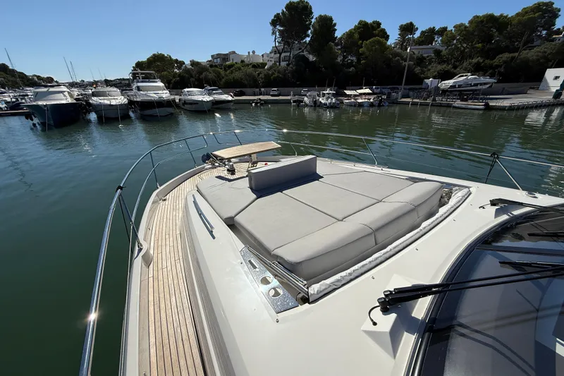  Yacht Photos Pics Luxurious 2024 Prestige 590 yacht with spacious sunbathing area, docked in a serene marina.