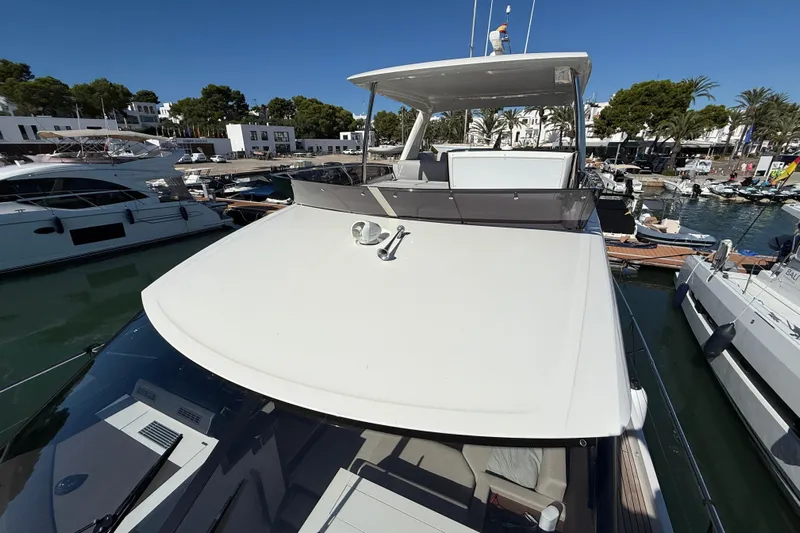  Yacht Photos Pics Prestige 590 yacht, 2024 model, docked in a sunny marina with surrounding boats.