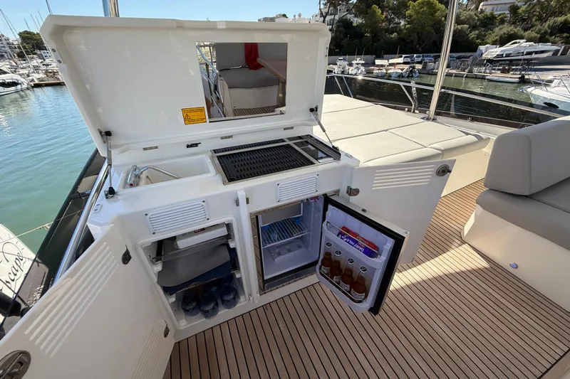  Yacht Photos Pics Outdoor kitchen on 2024 Prestige 590 yacht with grill and mini fridge.