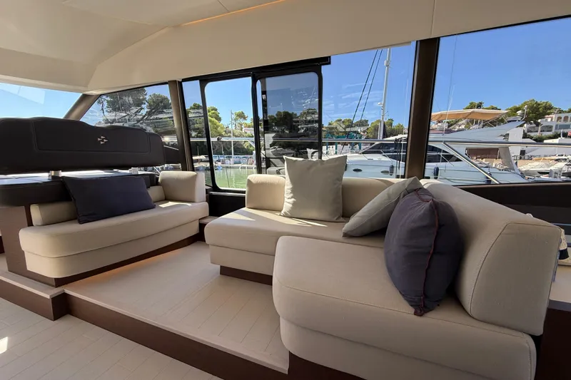  Yacht Photos Pics Luxurious interior of 2024 Prestige 590 yacht with elegant seating and marina view.