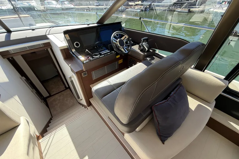  Yacht Photos Pics 2024 Prestige 590 yacht helm station with luxurious seating and modern controls.
