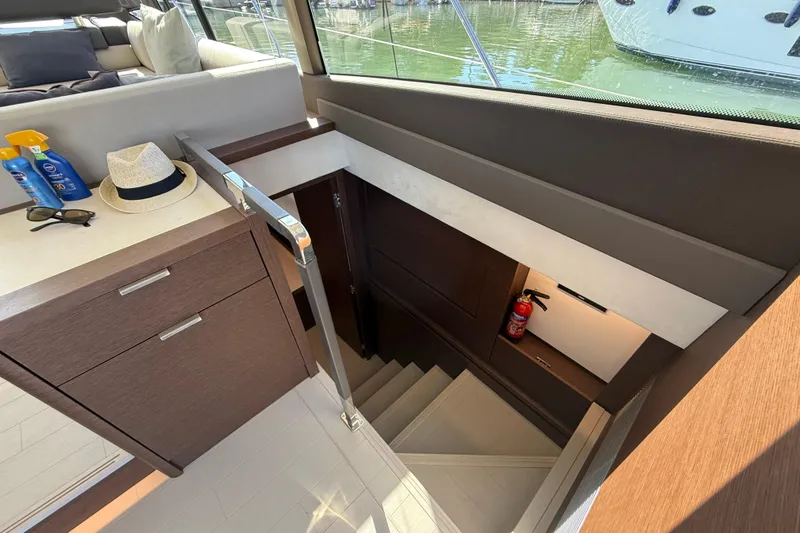  Yacht Photos Pics Interior of 2024 Prestige 590 yacht with stairs, cabinets, and safety equipment.