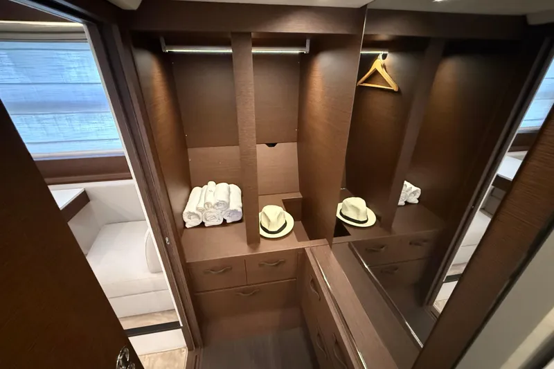  Yacht Photos Pics Luxurious 2024 Prestige 590 yacht interior with elegant wooden closet and accessories.
