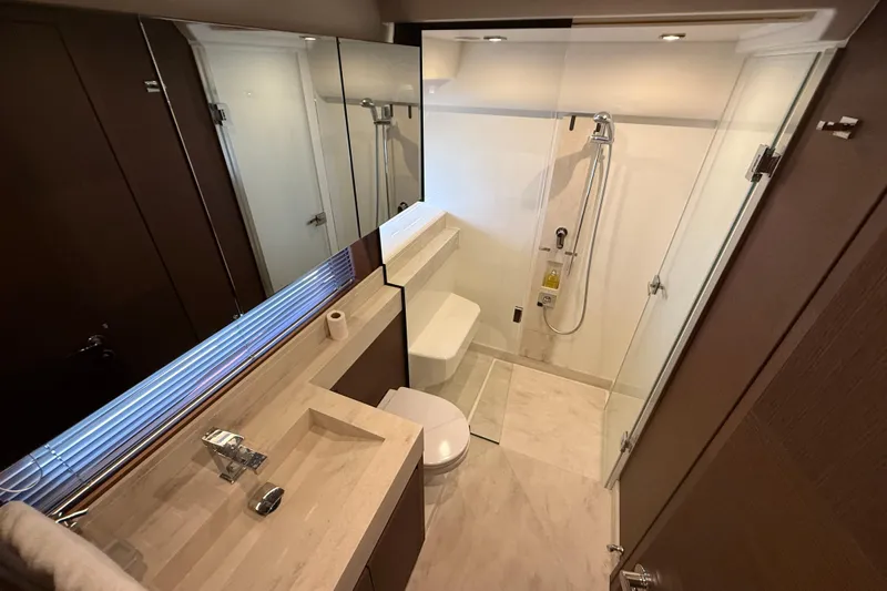  Yacht Photos Pics Luxurious bathroom in 2024 Prestige 590 yacht with modern fixtures and glass shower.