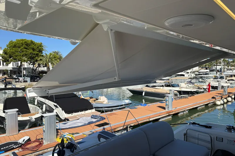  Yacht Photos Pics 2024 Prestige 590 yacht with retractable awning at marina dock.